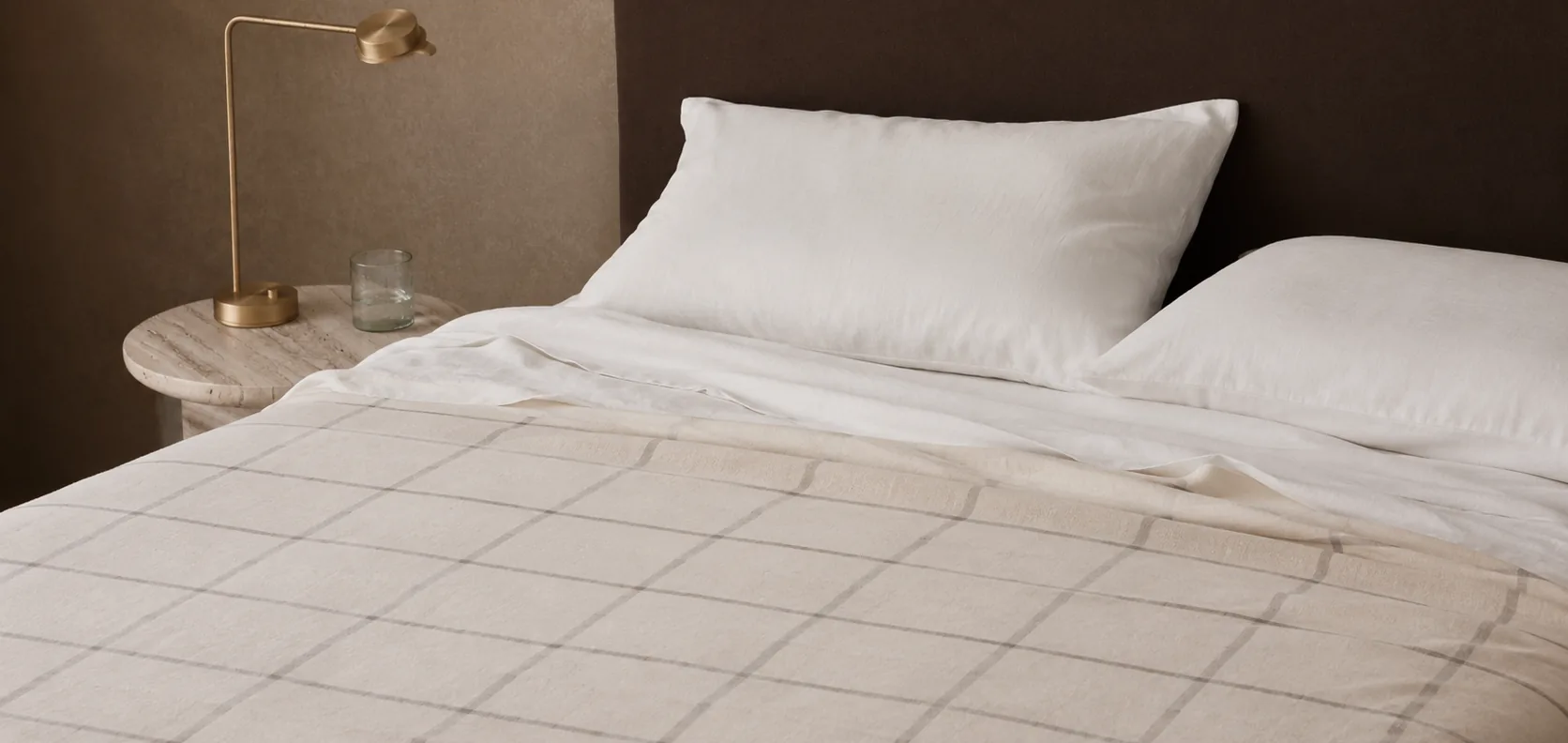 Cama tendida con sábanas blancas y manta a cuadros, ropa de cama Brescia